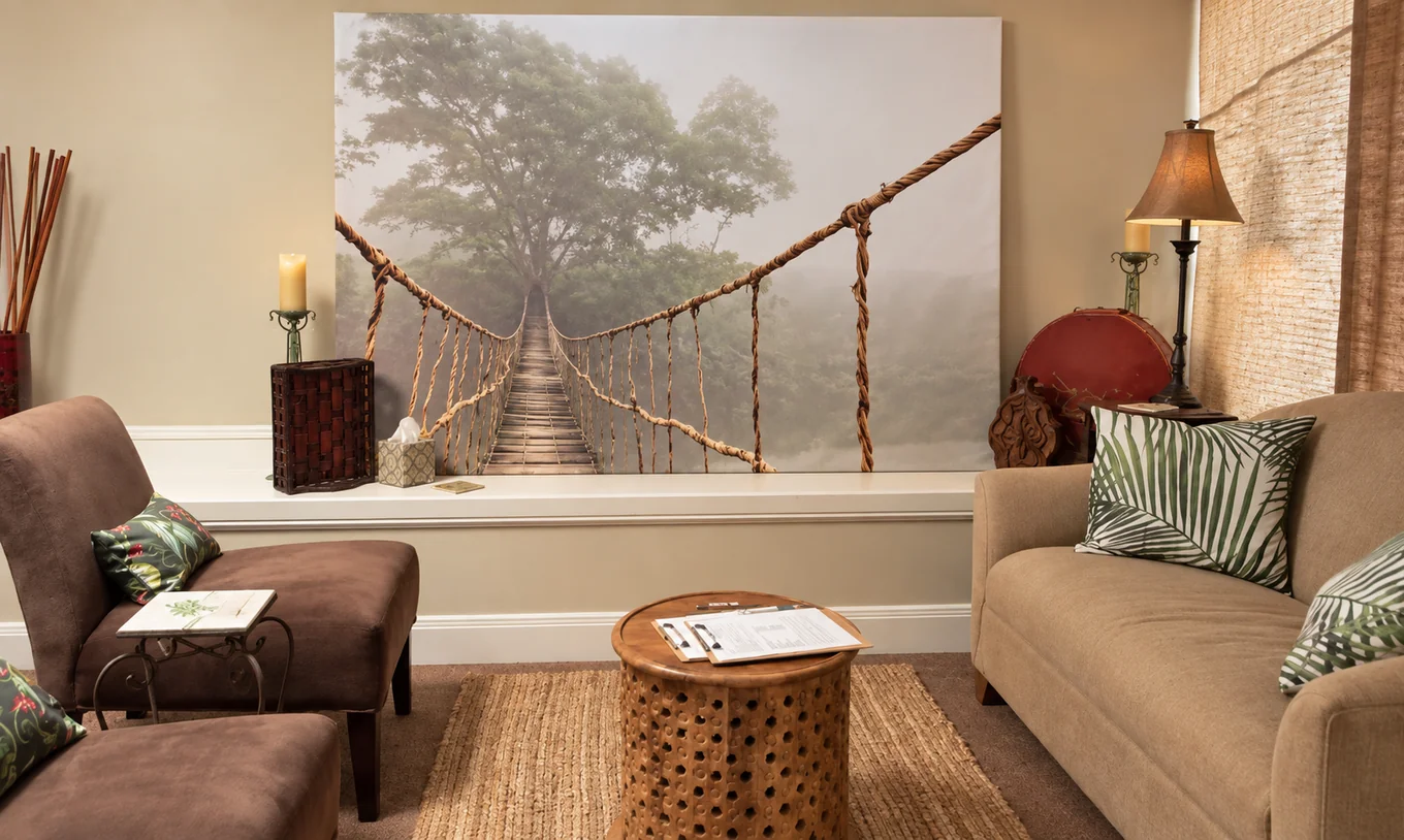 The studio’s welcoming sitting area with botanical cushions and a suspension-bridge artwork